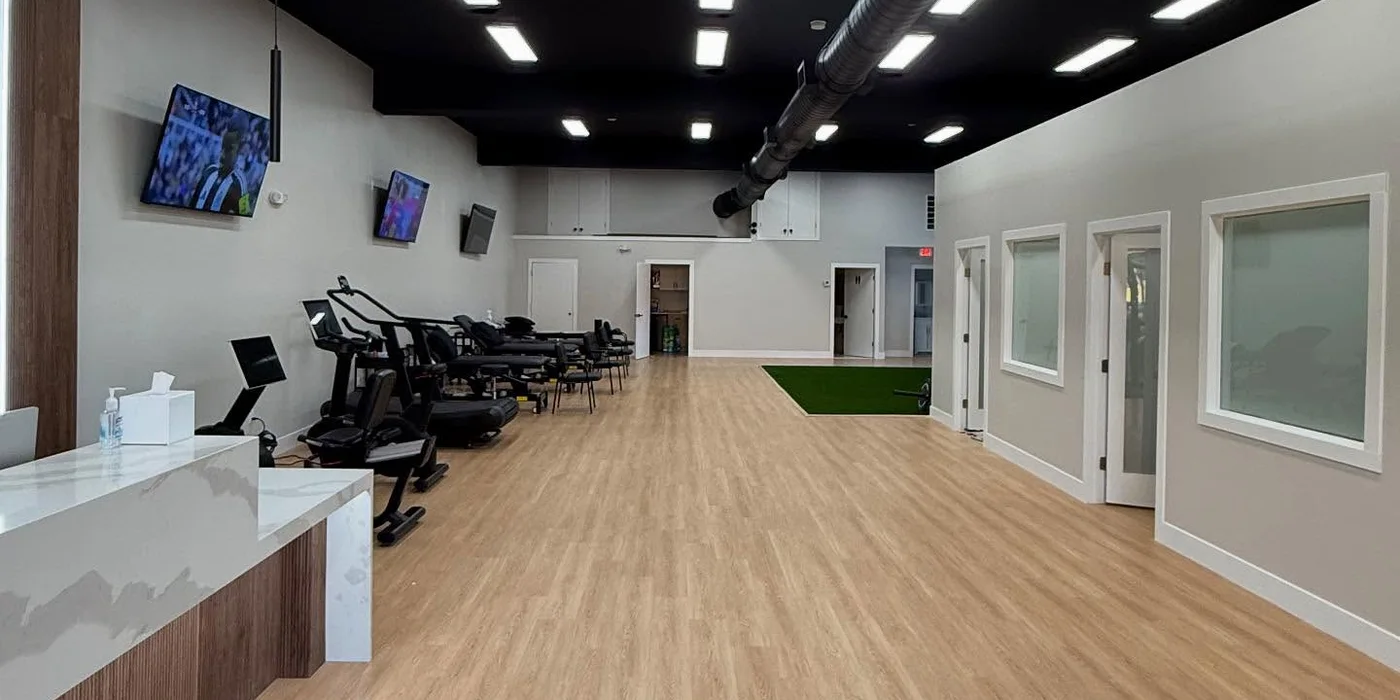 Treatment tables along the open floor, looking towards the private rooms